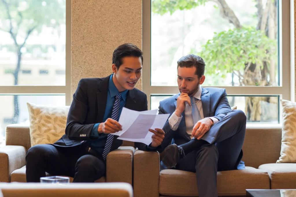 Business owner and advisor reviewing sale documents to model the after-tax proceeds of a company exit