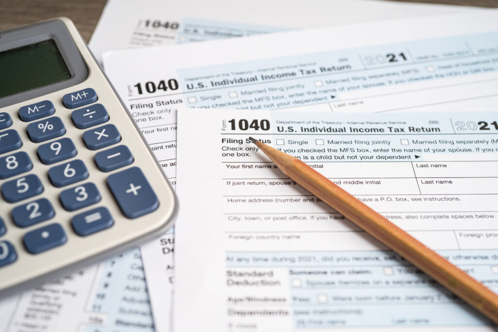 Individual income tax return and calculator representing the ordinary-income tax exposure inside a large traditional IRA balance